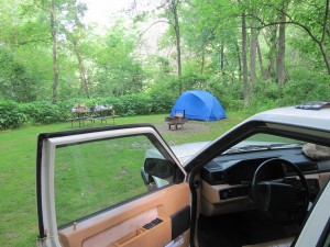 Car door open, tent and table above.
